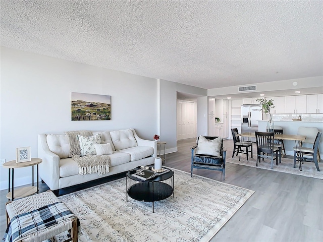 living room with hardwood / wood-style floors and a textured ceiling