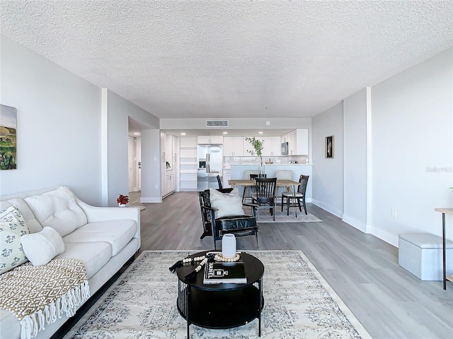 living room featuring light hardwood / wood-style floors and a textured ceiling