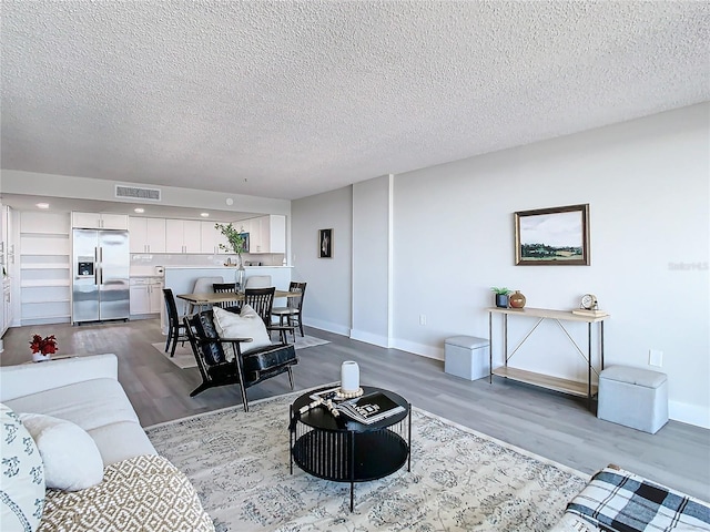 living room with hardwood / wood-style floors and a textured ceiling