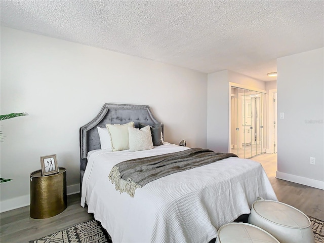 bedroom featuring a textured ceiling, light wood-type flooring, and a closet