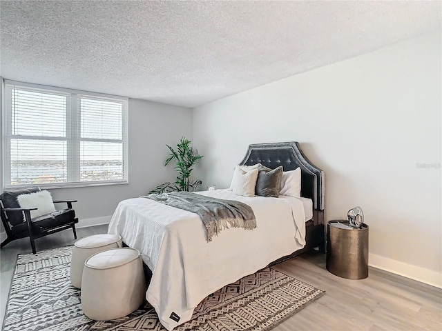 bedroom with a textured ceiling and light wood-type flooring