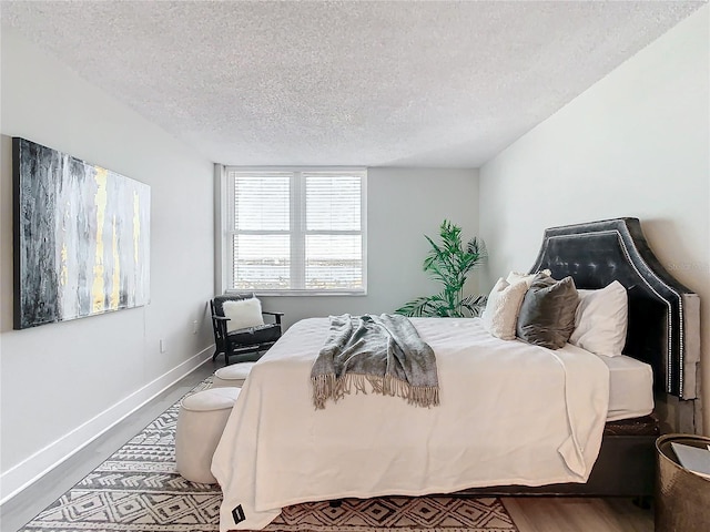 bedroom featuring hardwood / wood-style flooring and a textured ceiling