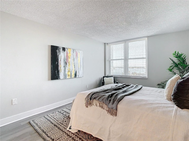 bedroom featuring wood-type flooring and a textured ceiling