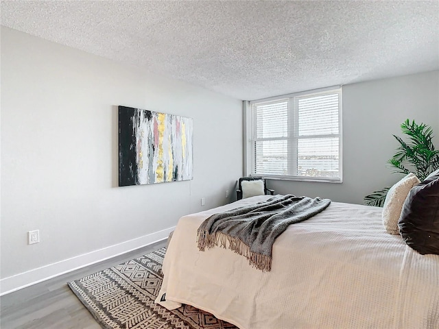 400 Island Way Unit 1411, Clearwater Beach, FL 33767 - bedroom featuring wood finished floors, baseboards, and a textured ceiling