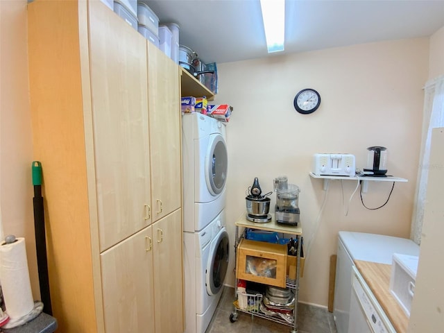 washroom with cabinets and stacked washer / dryer