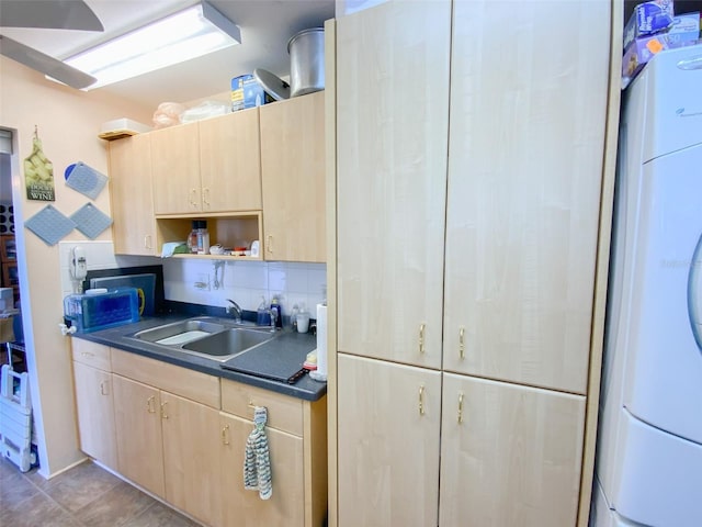 kitchen with tasteful backsplash, washer / clothes dryer, light brown cabinets, and sink