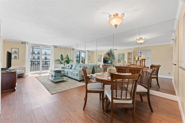 dining room with hardwood / wood-style floors and crown molding