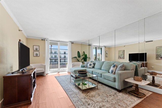 living room with light hardwood / wood-style flooring and crown molding