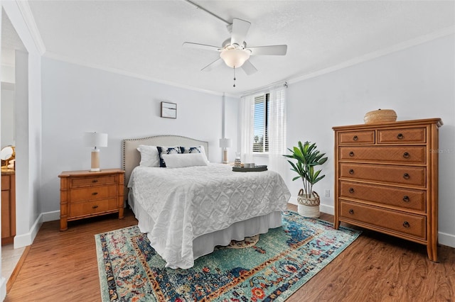 bedroom featuring ceiling fan, light wood-type flooring, and ornamental molding