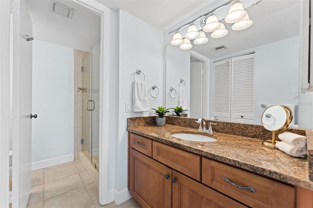 bathroom with tile patterned flooring, vanity, and a shower with door