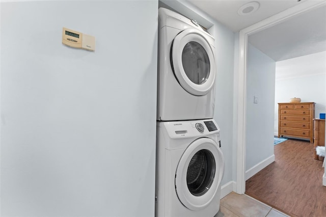 201 W Laurel St Unit 503, Tampa, FL 33602 - laundry area featuring stacked washing machine and dryer, baseboards, and light tile patterned floors