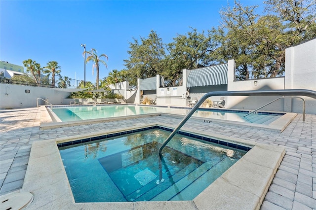 view of pool featuring a community hot tub and a patio