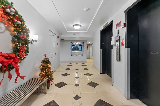 corridor with light tile patterned flooring and elevator