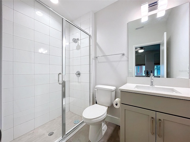 bathroom featuring toilet, an enclosed shower, and vanity