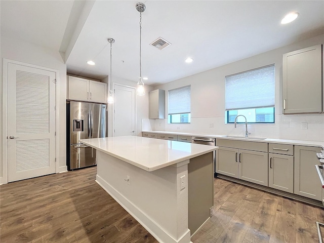 2511 N Grady Ave N Unit 59, Tampa, FL 33607 - kitchen featuring appliances with stainless steel finishes, a sink, a center island, tasteful backsplash, and wood finished floors