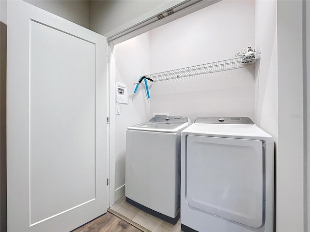 washroom featuring separate washer and dryer and light hardwood / wood-style floors