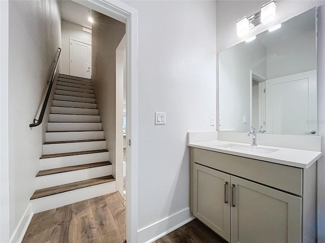 stairs with hardwood / wood-style flooring and sink