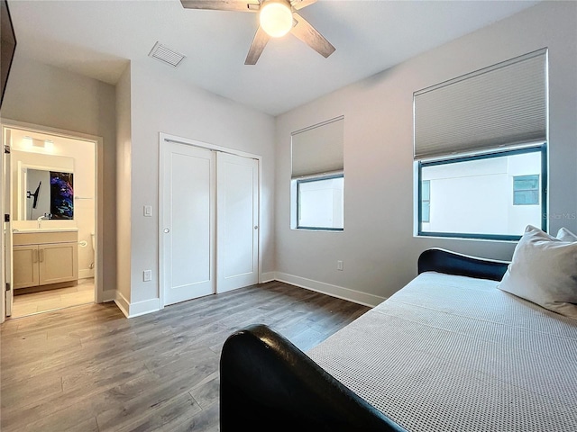 bedroom with ceiling fan, light wood-type flooring, and a closet