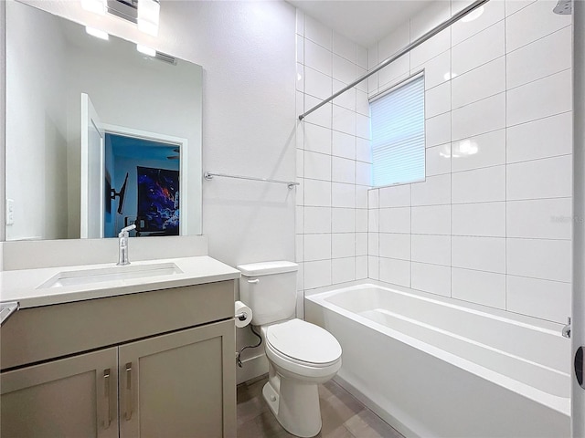 full bathroom featuring vanity, tiled shower / bath, and toilet