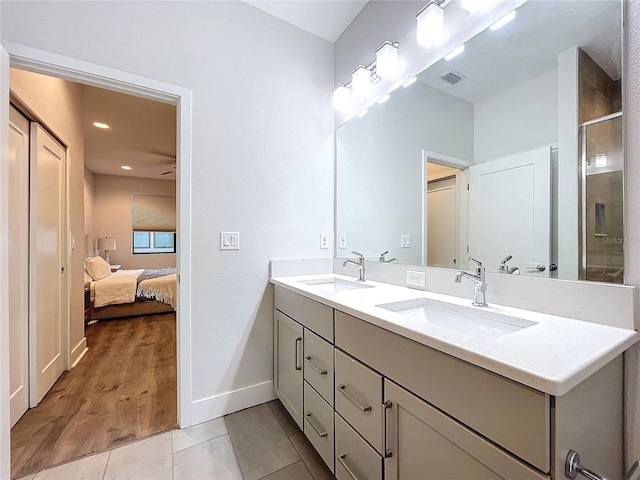 bathroom with hardwood / wood-style floors, vanity, and a shower with shower door