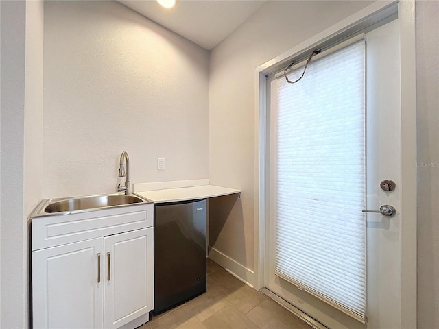 kitchen with white cabinetry, dishwasher, and sink