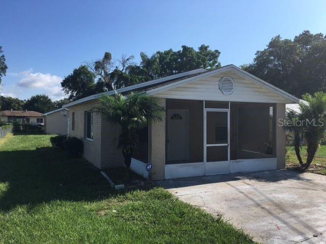 single story home with a sunroom and a front yard