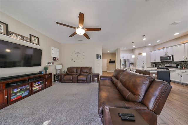 living room with light hardwood / wood-style flooring and ceiling fan