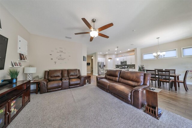 6337 Waves End Pl, Apollo Beach, FL 33572 - living room featuring a chandelier, a ceiling fan, baseboards, recessed lighting, and light wood-style floors