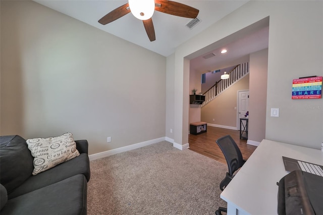 carpeted office space with ceiling fan