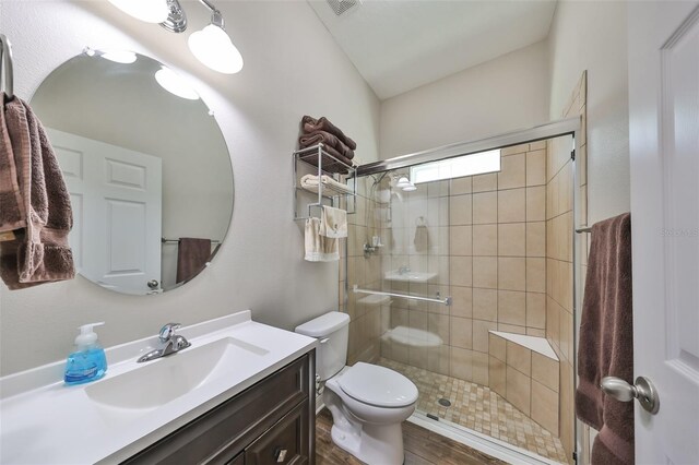 bathroom featuring hardwood / wood-style floors, vanity, toilet, and a shower with shower door