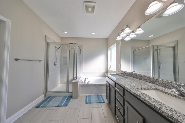 bathroom with vanity and shower with separate bathtub