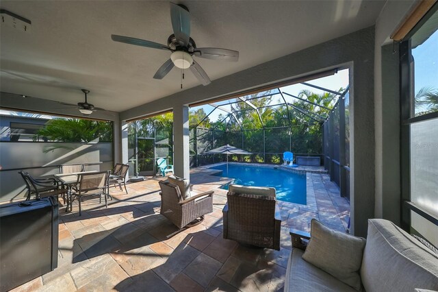 6337 Waves End Pl, Apollo Beach, FL 33572 - swimming pool with ceiling fan, a patio area, outdoor dining area, and glass enclosure