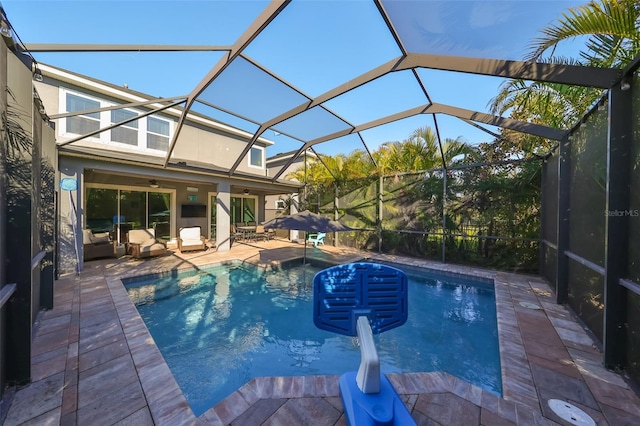 view of swimming pool with a patio area, ceiling fan, and glass enclosure