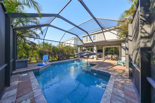 view of pool featuring a lanai, ceiling fan, and a patio area