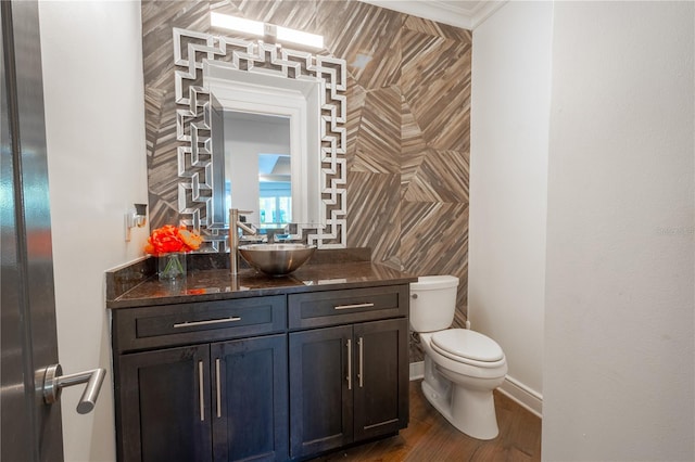 bathroom featuring vanity, crown molding, wood-type flooring, and toilet