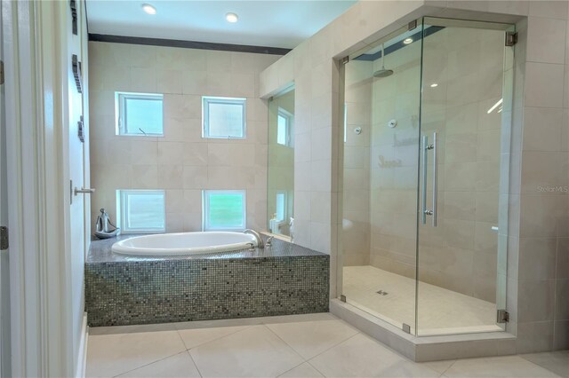 bathroom featuring shower with separate bathtub, tile patterned flooring, and tile walls