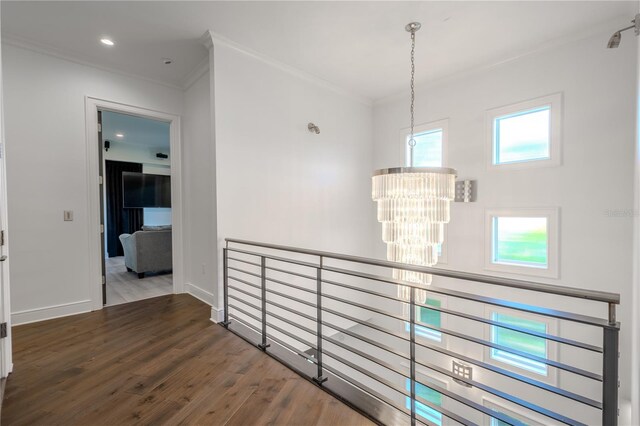 hallway featuring an inviting chandelier, crown molding, and dark hardwood / wood-style flooring