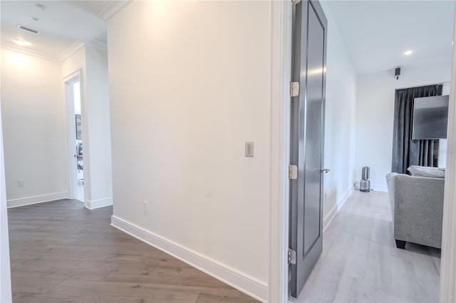 hallway with crown molding and light wood-type flooring