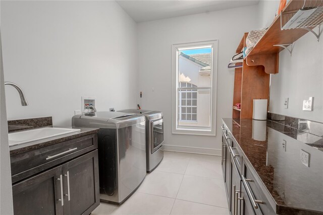 washroom featuring a healthy amount of sunlight, sink, washer and dryer, and light tile patterned floors