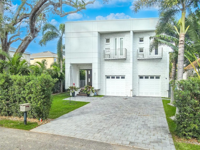 view of front of property with a garage, a front yard, and a balcony