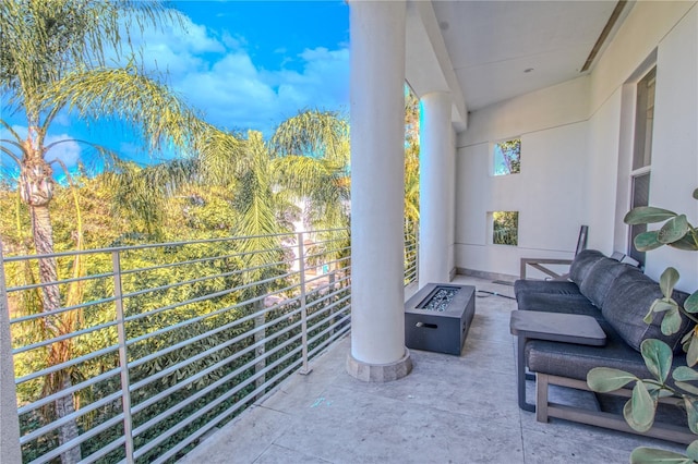 balcony featuring an outdoor living space with a fire pit