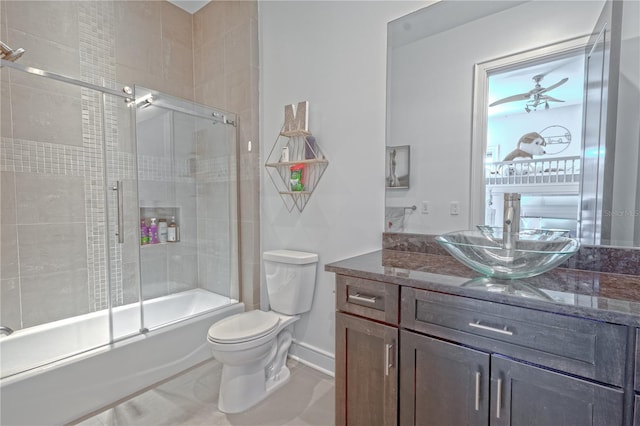 full bathroom featuring toilet, vanity, bath / shower combo with glass door, and tile patterned flooring