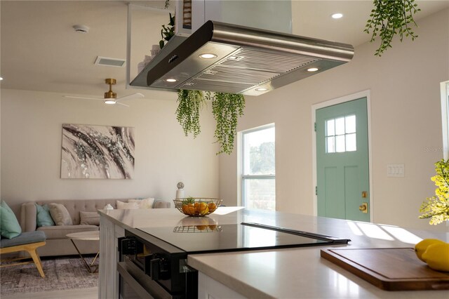 kitchen featuring island exhaust hood, ceiling fan, and stainless steel electric range