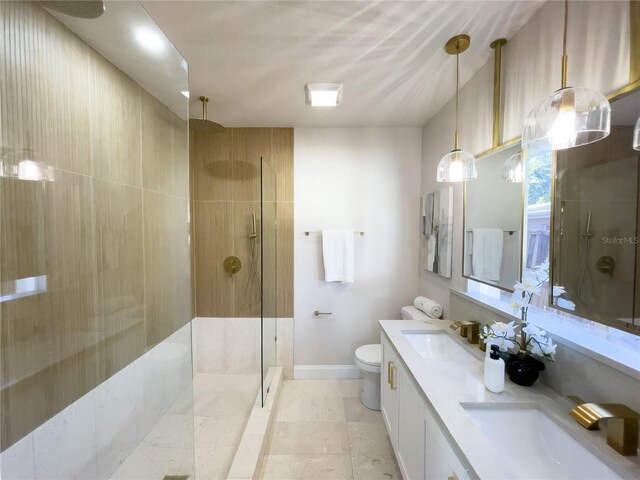 bathroom featuring a tile shower, vanity, and toilet