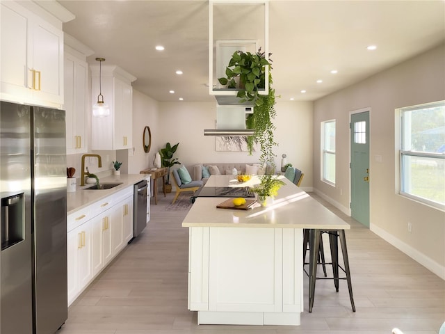 5516 Golden Dr, Tampa, FL 33634 - kitchen featuring stainless steel appliances, a sink, light wood-style flooring, light countertops, and recessed lighting