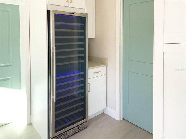 bar featuring wine cooler and white cabinetry