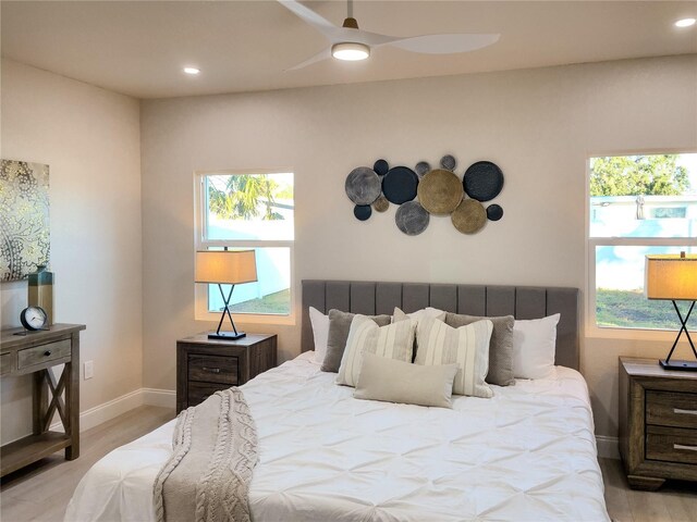 bedroom with multiple windows, ceiling fan, and light wood-type flooring