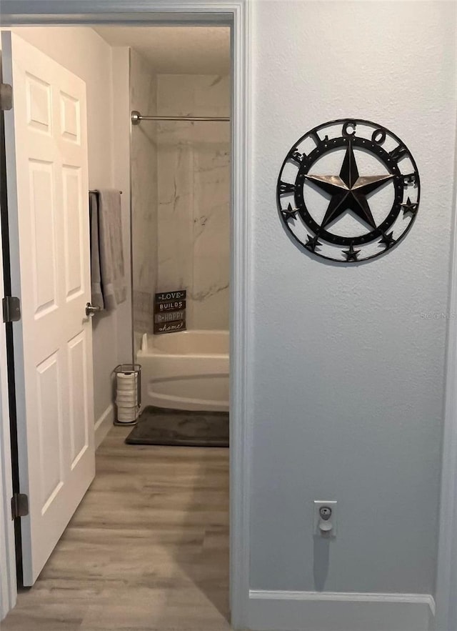 bathroom featuring hardwood / wood-style flooring and tiled shower / bath