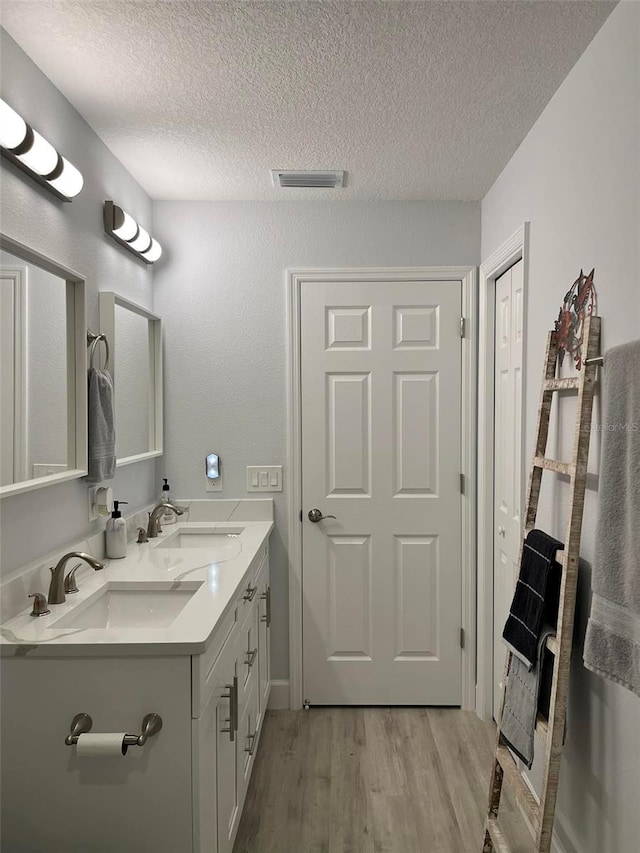 bathroom with vanity, hardwood / wood-style floors, and a textured ceiling