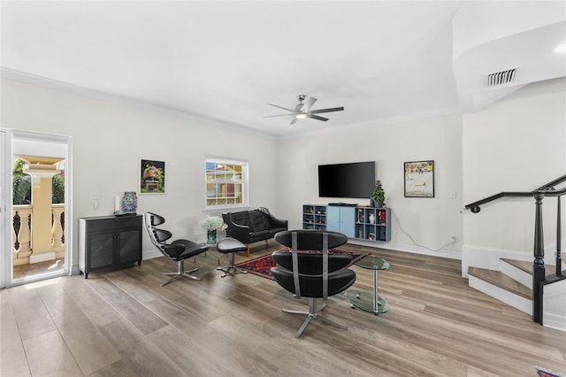 interior space featuring ceiling fan, light wood-type flooring, and crown molding